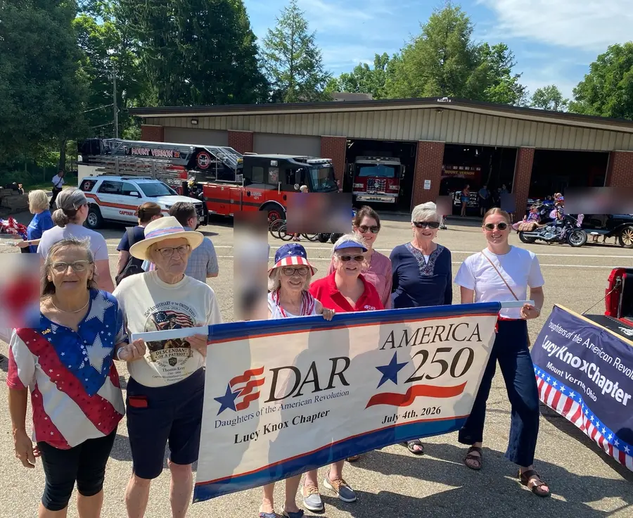 Chapter members marching with the DAR America 250 and Lucy Knox Chapter banners