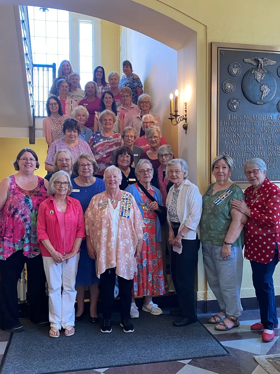 Chapter members dressed in pink gathered on a staircase
