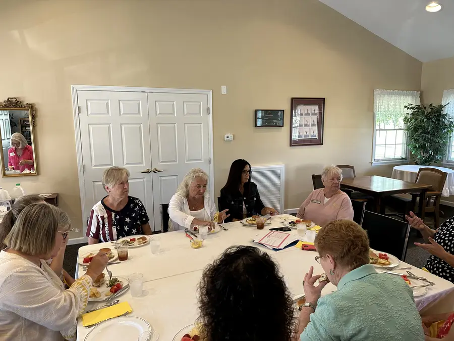 Members chatting over lunch in a sunny room