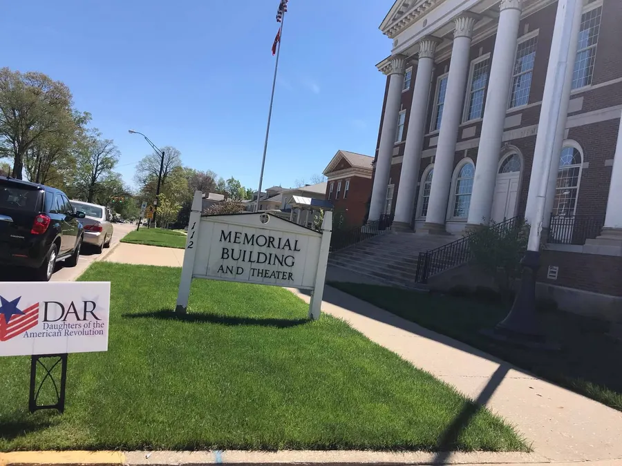 The Memorial Building and Theater sign with a DAR yard sign