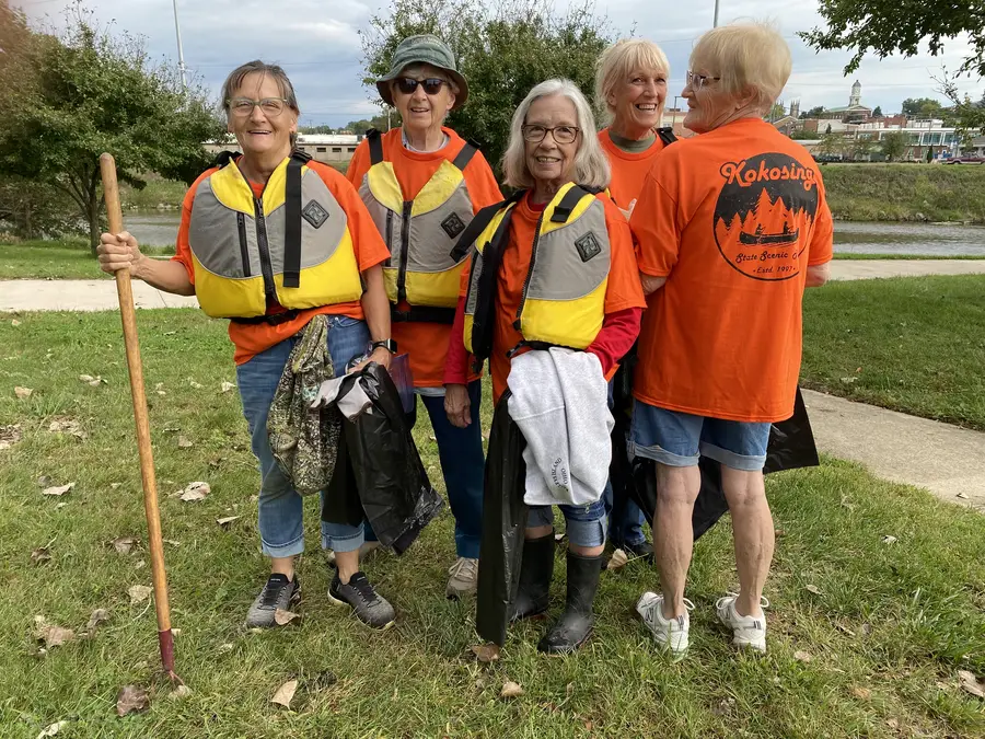 Chapter members in life jackets and orange shirts with trash bags and grabbers after the cleanup