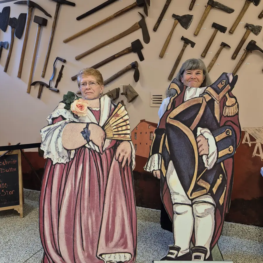 Two more members posing in the colonial cutout boards