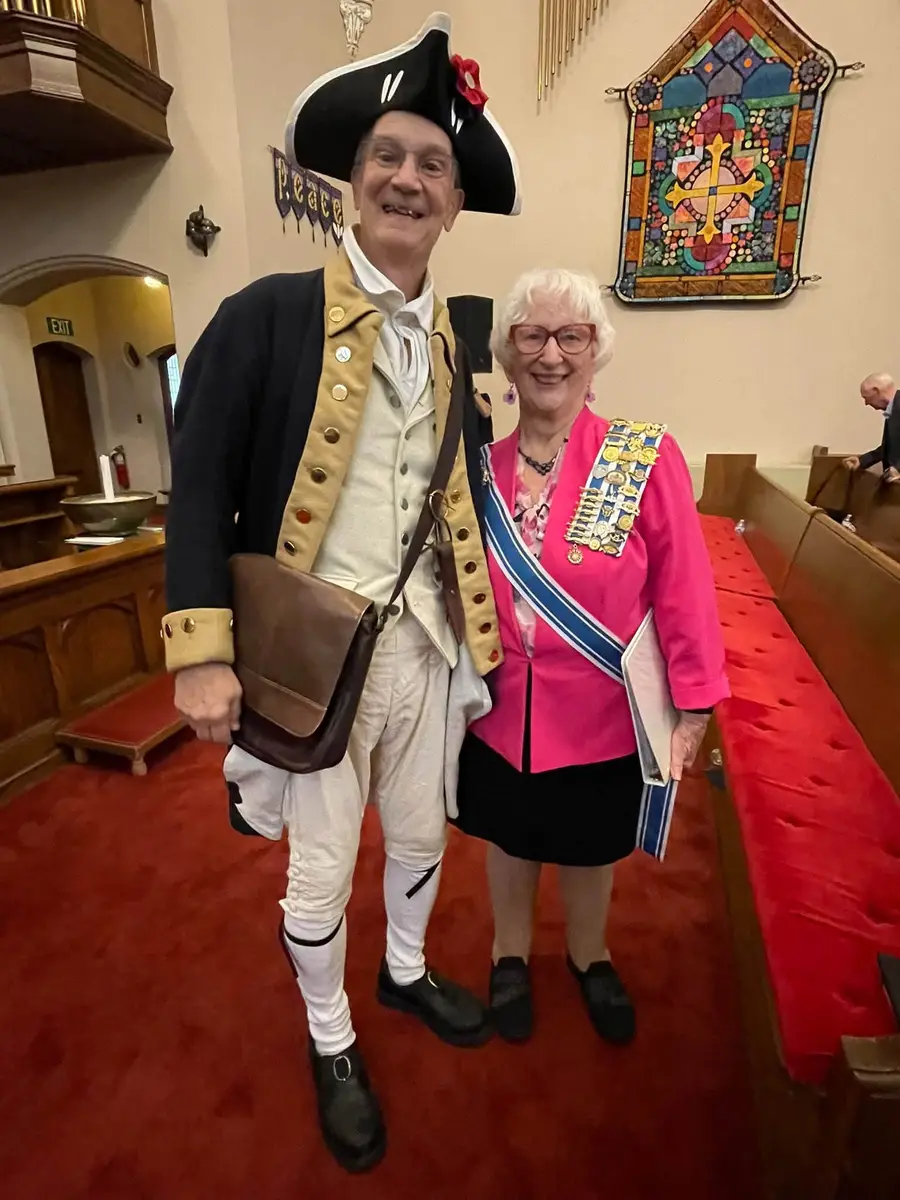 A colonial reenactor with a chapter member