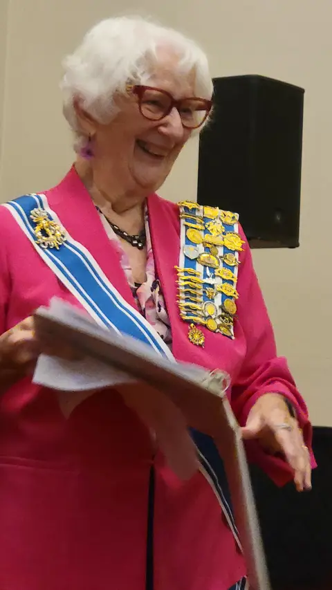 A community reader at the podium reading from the Constitution