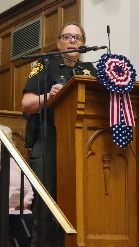 A community reader at the podium reading from the Constitution