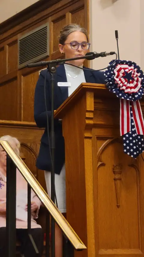 A community reader at the podium reading from the Constitution