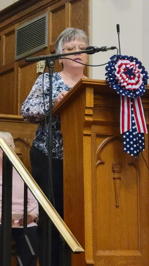 A community reader at the podium reading from the Constitution