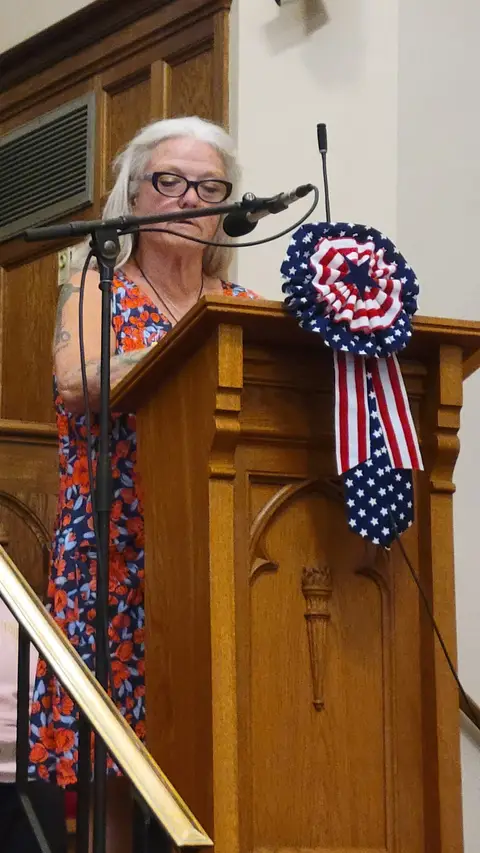 A community reader at the podium reading from the Constitution